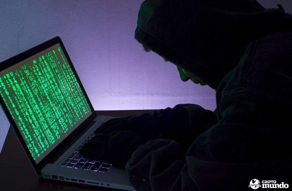 hooded-figure-hacking-on-a-laptop